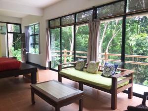 a living room filled with furniture and large windows at Gaze Studio: Modern Spacious Jungle Stay in Pantai Cenang