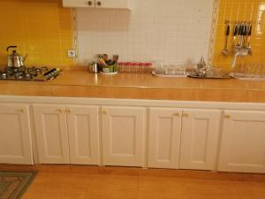 a kitchen with white cabinets and a counter top at Huge Cozy Apartment in Larache