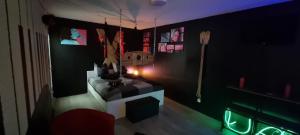 ストラスブールにあるLe Coin des Désirs BDSMの壁にテーブルと照明が付いた暗い部屋 +8枚の写真