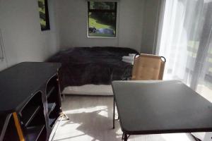 - une chambre avec un lit, une table et des chaises dans l'établissement Cable Bay Farm, à Nelson