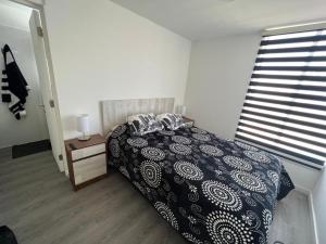 een slaapkamer met een zwart-wit bed en een raam bij Casa Playa el Tabo en Condominio Estilo Mediterraneo in El Tabo