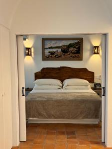 a bedroom with a large bed and a painting on the wall at OceanBlue Resort in Christ Church