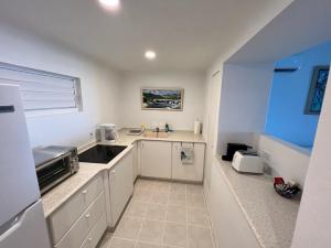a kitchen with white cabinets and a sink at OceanBlue Resort in Christ Church