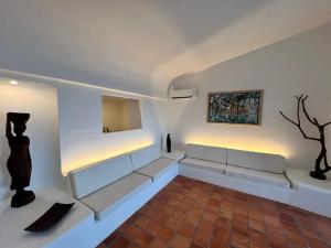 a living room with two benches and a painting on the wall at OceanBlue Resort in Christ Church