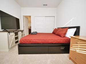 a bedroom with a red bed and a flat screen tv at Luxury 3 Bedroom House Near Sacramento Airport in Sacramento