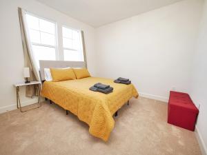 a bedroom with a bed with a yellow bedspread at Luxury 3 Bedroom House Near Sacramento Airport in Sacramento