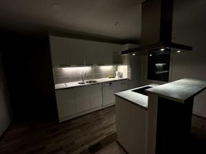 una cucina con armadi bianchi e piano di lavoro nero di Spectacular Suite With Sauna a Rovaniemi