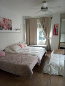 sypialnia z 2 łóżkami i wentylatorem sufitowym w obiekcie Chalet Urbanización Alcolea w Kordobie