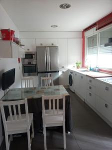a kitchen with a table and chairs and a refrigerator at Chalet Urbanización Alcolea in Córdoba