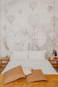 una camera da letto con un letto con mongolfiere sul muro di Ortigia Suite - Don Diego a Siracusa