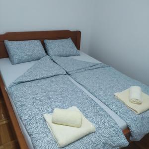 1 cama con 2 toallas y 2 almohadas en Apartman LiSA, en Banja Koviljača