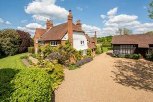 a large house with a pathway leading to it at 6 Bed Countryside Mansion With Tennis Court & Swimming Pool with Parking in East Horsley