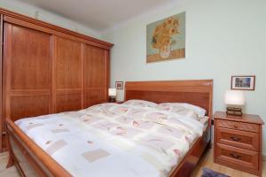 ein Schlafzimmer mit einem großen Bett und einem Kopfteil aus Holz in der Unterkunft Apartment Dante Alighieri in Opatija