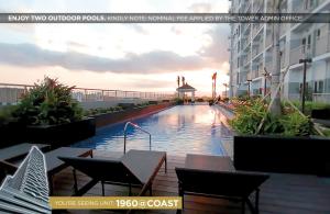 a swimming pool with tables and chairs next to a building at Home Sweet Home at Manila Bay in Manila