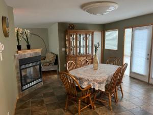 ein Esszimmer mit einem Tisch, Stühlen und einem Kamin in der Unterkunft Lakeshore Guest House - sleeps 18 in Sylvan Lake