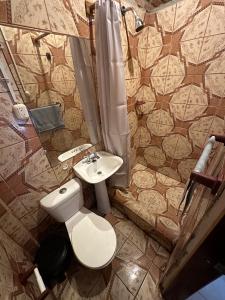 a bathroom with a toilet and a sink at Malevo Suites - Apartments in Ayampe