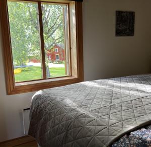 a bedroom with a bed and a large window at Highnoon Westernranch guesthouse in Ljusdal