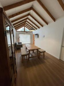 sala de estar con mesa de madera y bancos en Casa nueva de playa 3D 2B en El Quisco