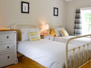 1 dormitorio con 2 camas y vestidor en The Old School House Cottage, en Coupar Angus