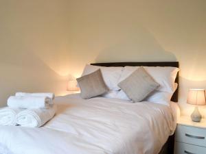 Un dormitorio con una cama blanca con toallas. en Offas Dyke Lodge - Uk10835, en Old Radnor