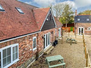 a brick house with a picnic table in front of it at The Willows - Uk34000 in Child Okeford