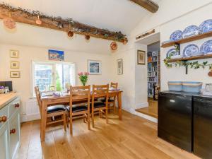 uma cozinha e sala de jantar com uma mesa de madeira e cadeiras em The Smithy - E5445 em Brassington