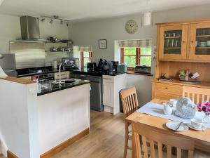 a kitchen with a table and a kitchen with a stove at The Lodge in Thakeham