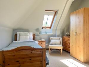 The Lodge في Thakeham: غرفة نوم بسرير وخزانة وكرسي