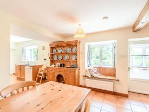 a kitchen with a wooden table and a dining room at Town Head Cottage in Carlton