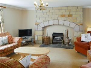 a living room with a brick fireplace and a table at The Mill House in Warenford