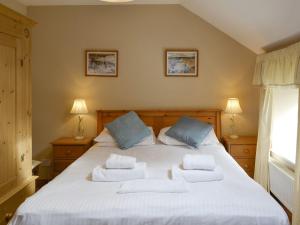 a bedroom with a large white bed with two pillows at The Mill House in Warenford
