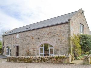 an old stone building with a stone wall at The Mill House in Warenford