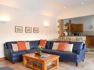 uma sala de estar com um sofá azul e uma mesa em Riccal Heads em Lastingham