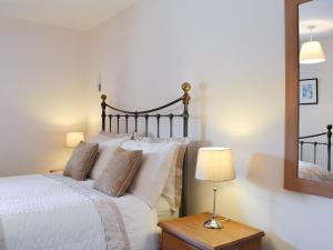 um quarto com uma cama com um candeeiro e um espelho em Riccal Heads em Lastingham