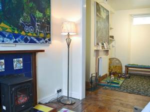 a living room with a fireplace and a lamp at Seagulls in Holyhead
