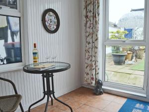 a table in a room with a window and a bottle of wine at Seagulls in Holyhead