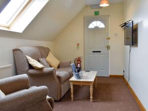 a living room with a couch and a table at Kimberley Apartment in Alness