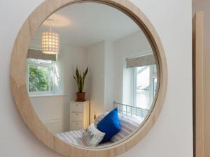 a mirror hanging on a wall in a bedroom at College View 2 Upper in Kingswear