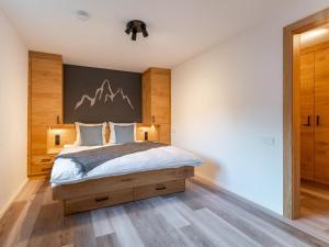 a bedroom with a large bed with a wooden headboard at Villa Felding top 1 in Bad Hofgastein