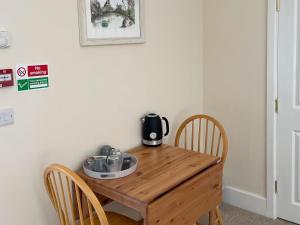 una mesa de madera con una cafetera encima en The Old Kitchen -uk32062, en Burwarton