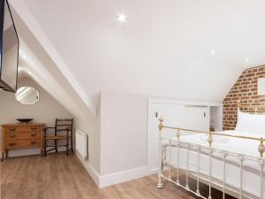 a white bedroom with a bed and a chair at Bank Apartment 2 in Dartmouth