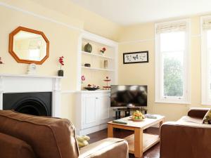 a living room with a fireplace and a television at Hamilton House in Royal Tunbridge Wells