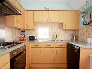 a kitchen with wooden cabinets and a sink at Hamilton House in Royal Tunbridge Wells