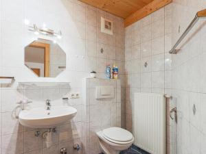 a white bathroom with a sink and a toilet at Igl Hof Top 4 in Westendorf