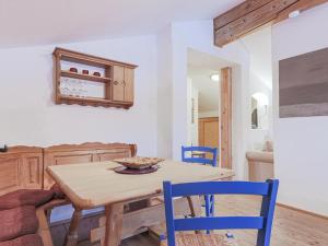 a kitchen with a wooden table and blue chairs at Igl Hof Top 4 in Westendorf