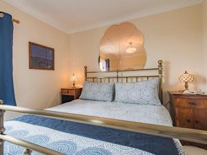 een slaapkamer met een bed en een spiegel aan de muur bij Helvetia in Dungeness