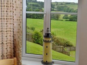 a lighthouse sitting in front of a window at Meadowside Apartment in Fowey