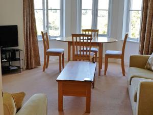 a living room with a couch and a table and chairs at Meadowside Apartment in Fowey
