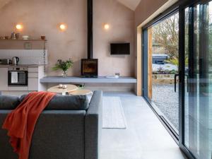 a living room with a couch and a kitchen at The Old Piggery in Stowting