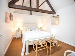 a bedroom with a white bed and two chairs at Peakaboo in Sidmouth
